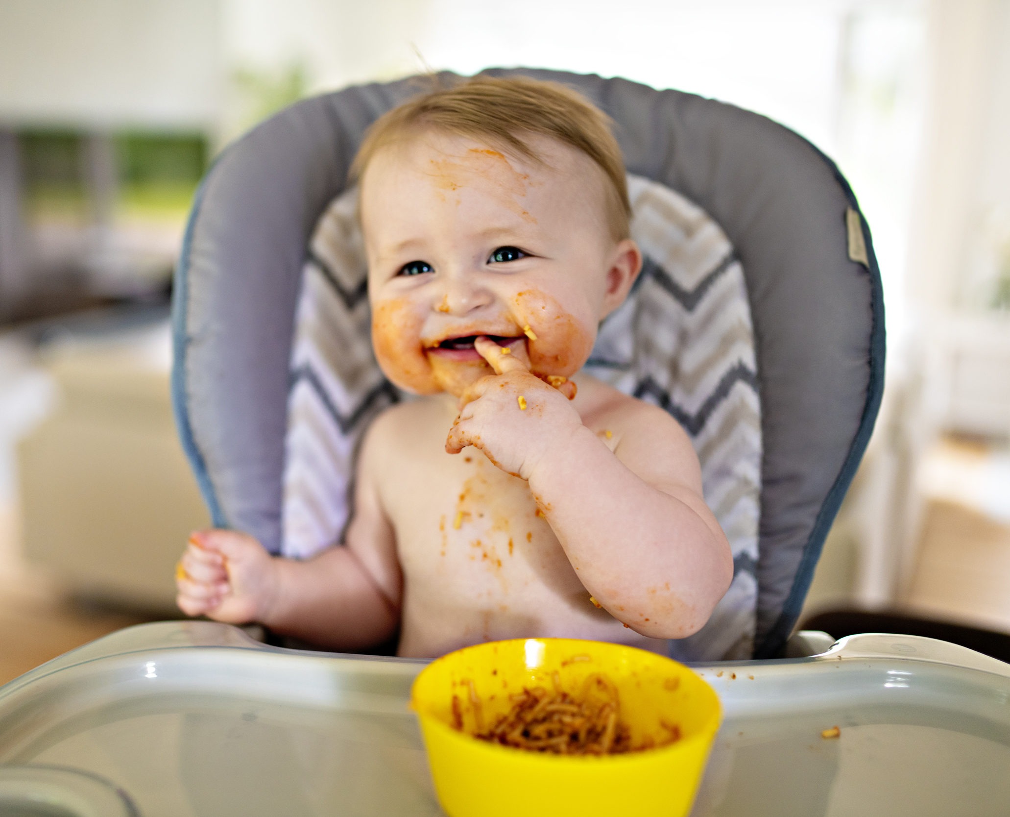 Ein kleines Baby isst ihr Abendessen und macht ein Chaos
